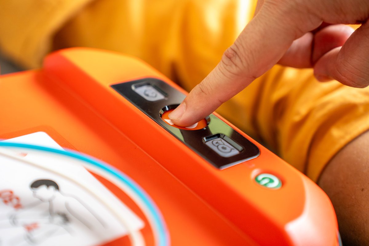 Pressing the shock button on an AED
