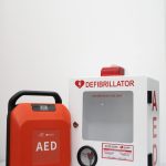 MyHeart Primedic S-Series AED with cabinet and AED signage