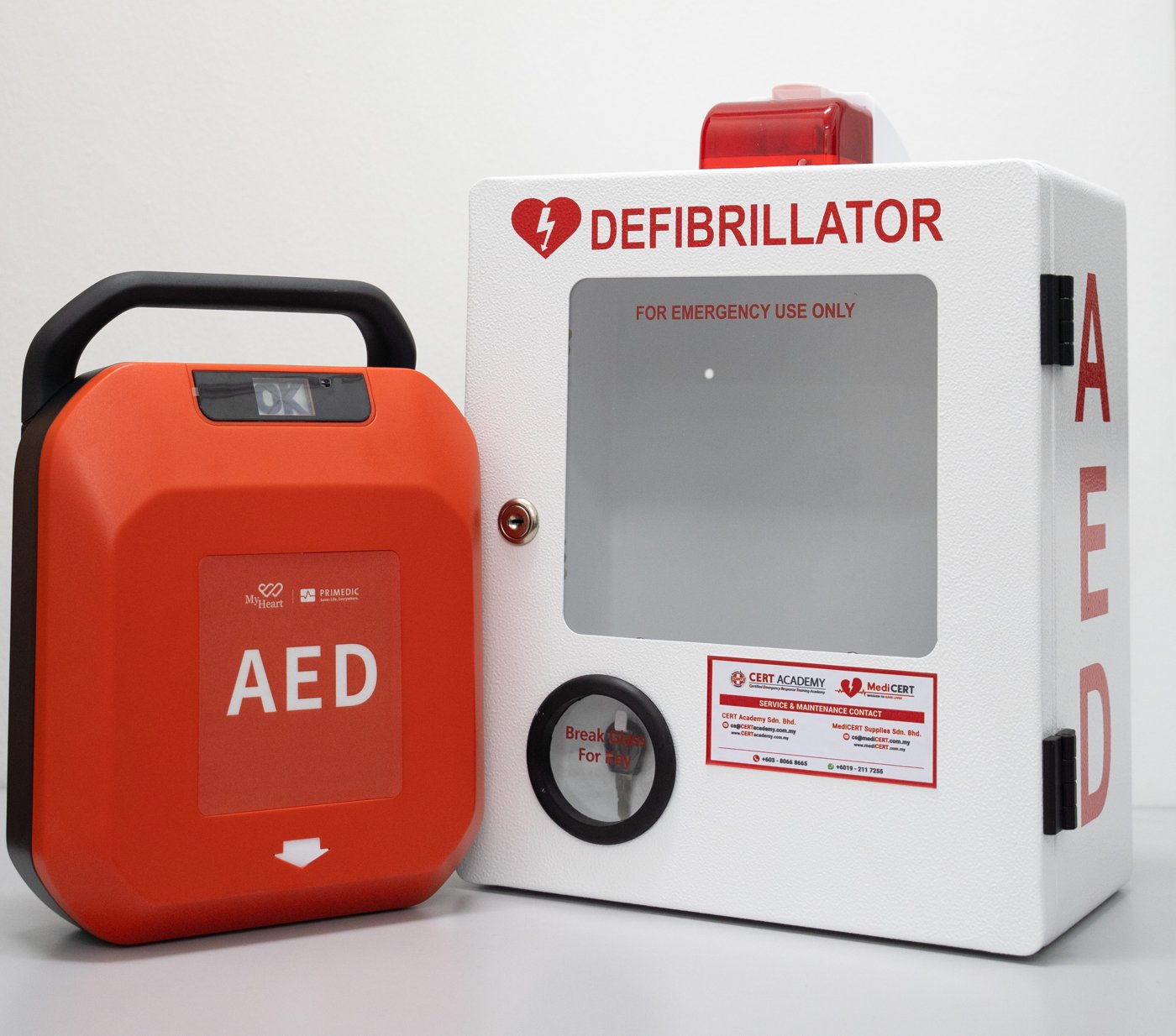 AED cabinet with alarm, siren and light, next to a MyHeart Primedic S-Series AED